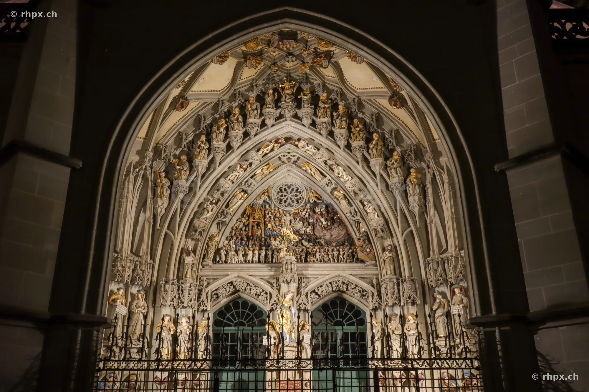 Detailansicht des steinernen Hauptportals mit dem Jüngsten Gericht am Berner Münster bei Nacht