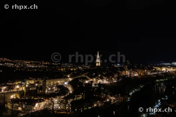 Nächtliche Stadtansicht von Bern mit beleuchtetem Berner Münster