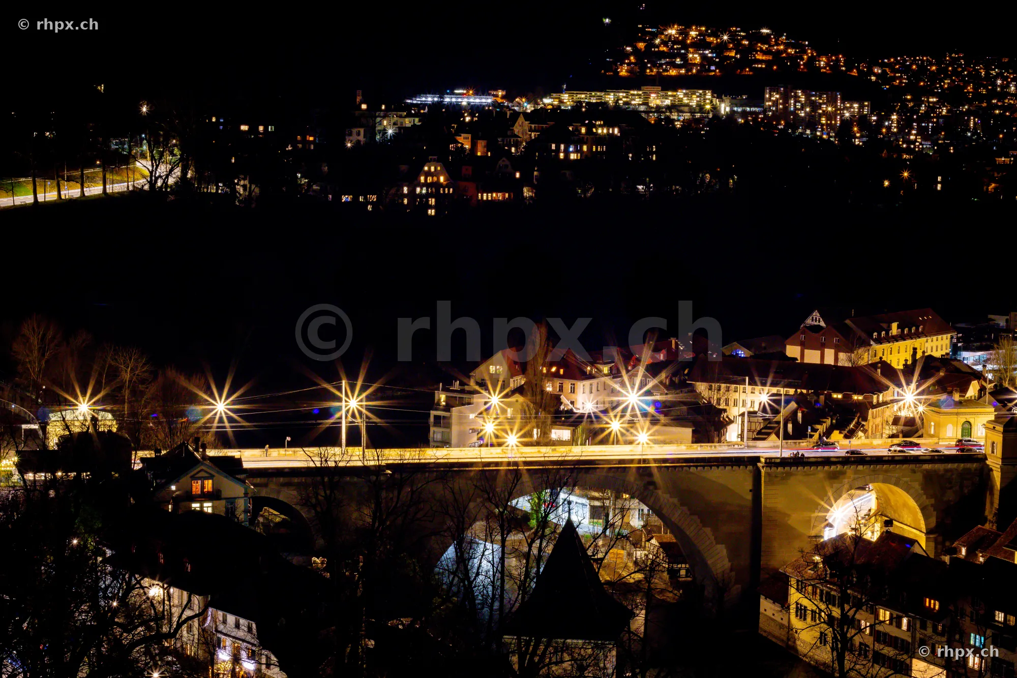 Die beleuchtete Nydeggbrücke in Bern über der dunklen Aare bei Nacht