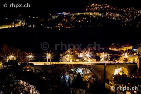 Die beleuchtete Nydeggbrücke in Bern über der dunklen Aare bei Nacht