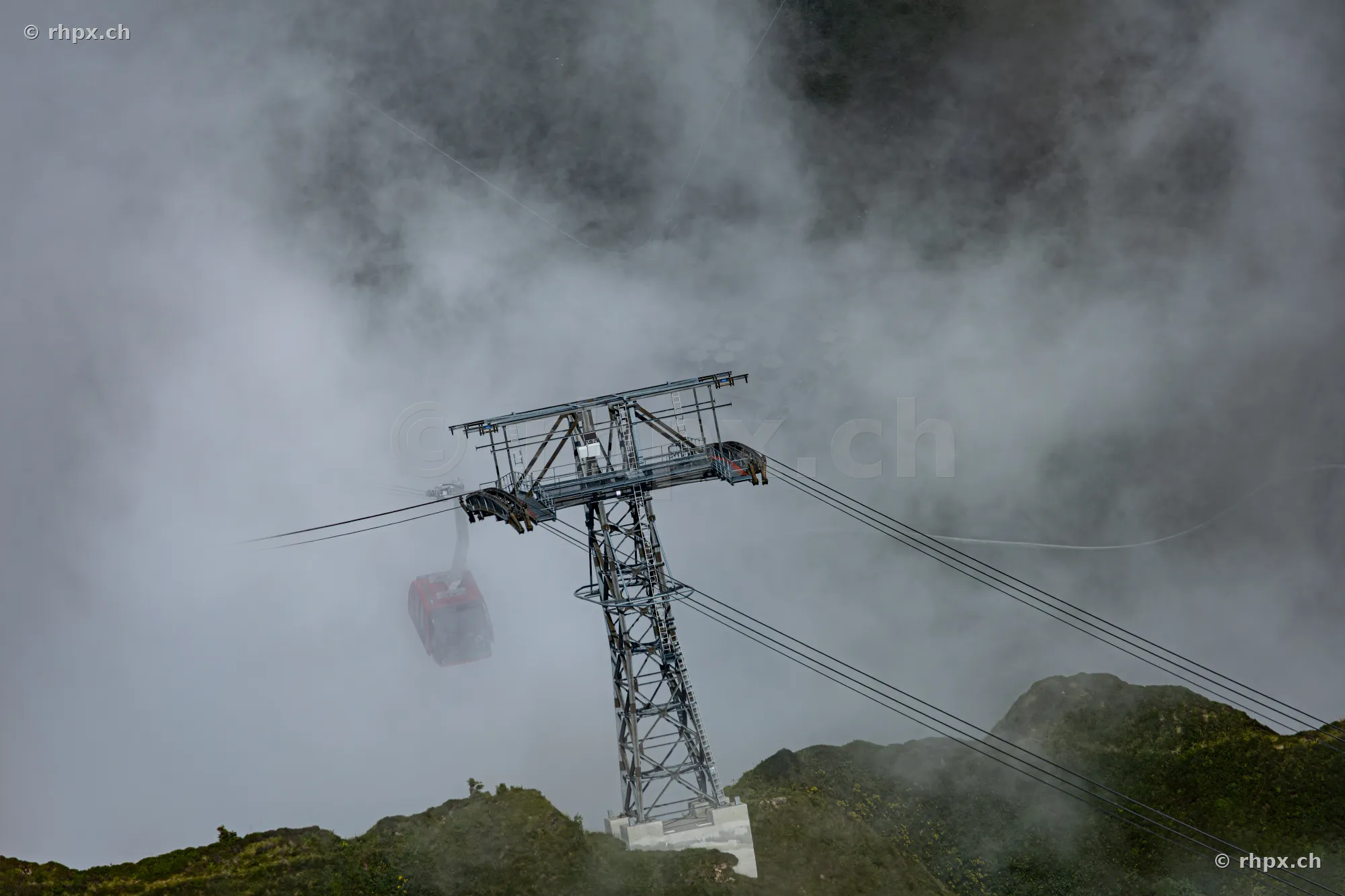 Pylon of the Pilatus aerial cableway in a foggy mountain landscape