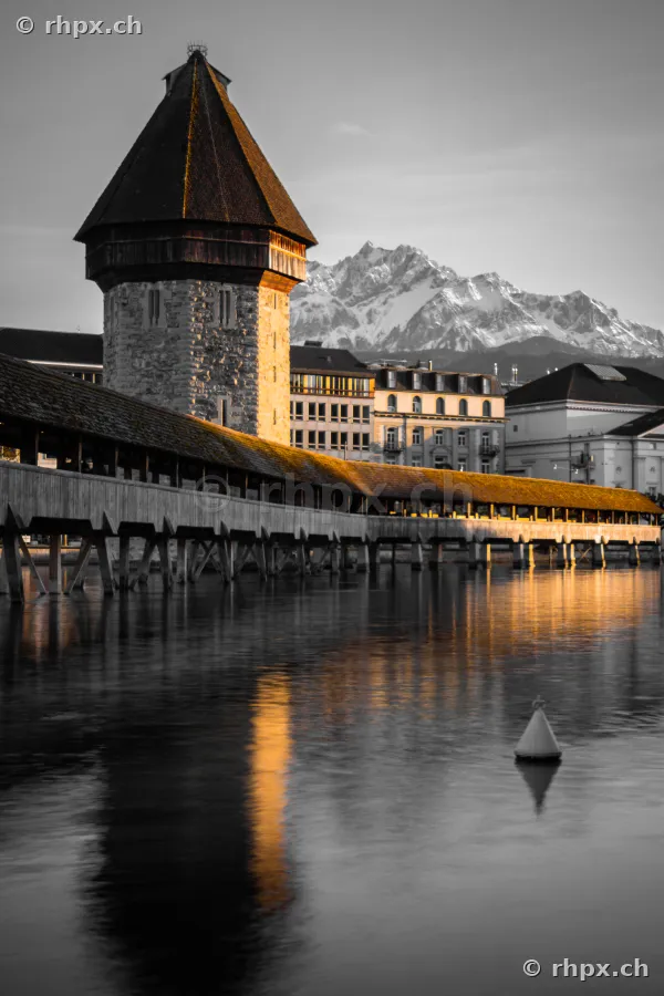 Die Kapellbrücke in Luzern mit dem Wasserturm und dem schneebedeckten Pilatus im Hintergrund