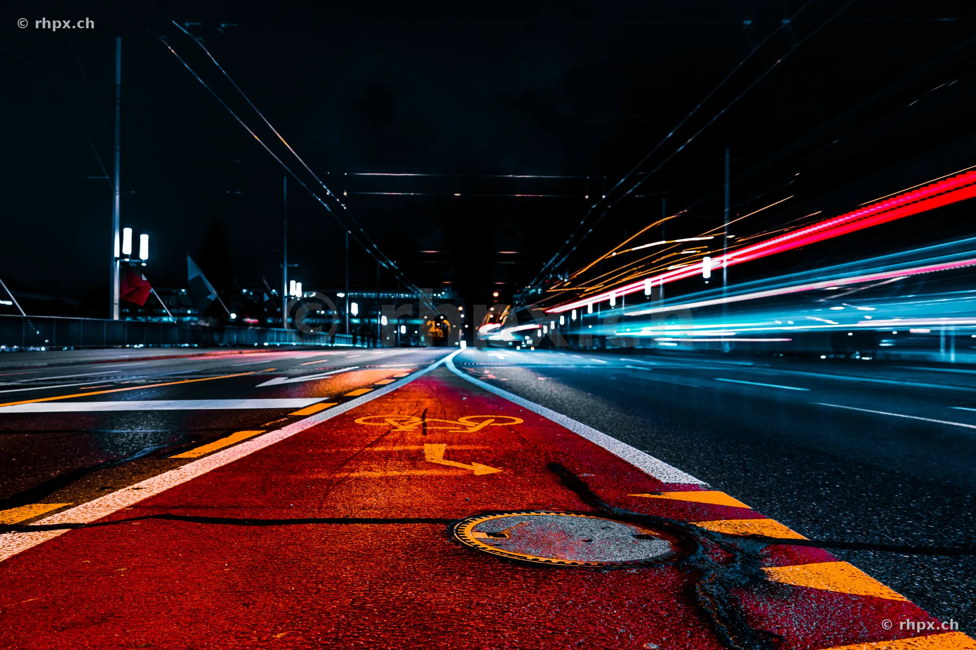 Night shot of a street in Lucerne with long exposure light trails on the cycle lane