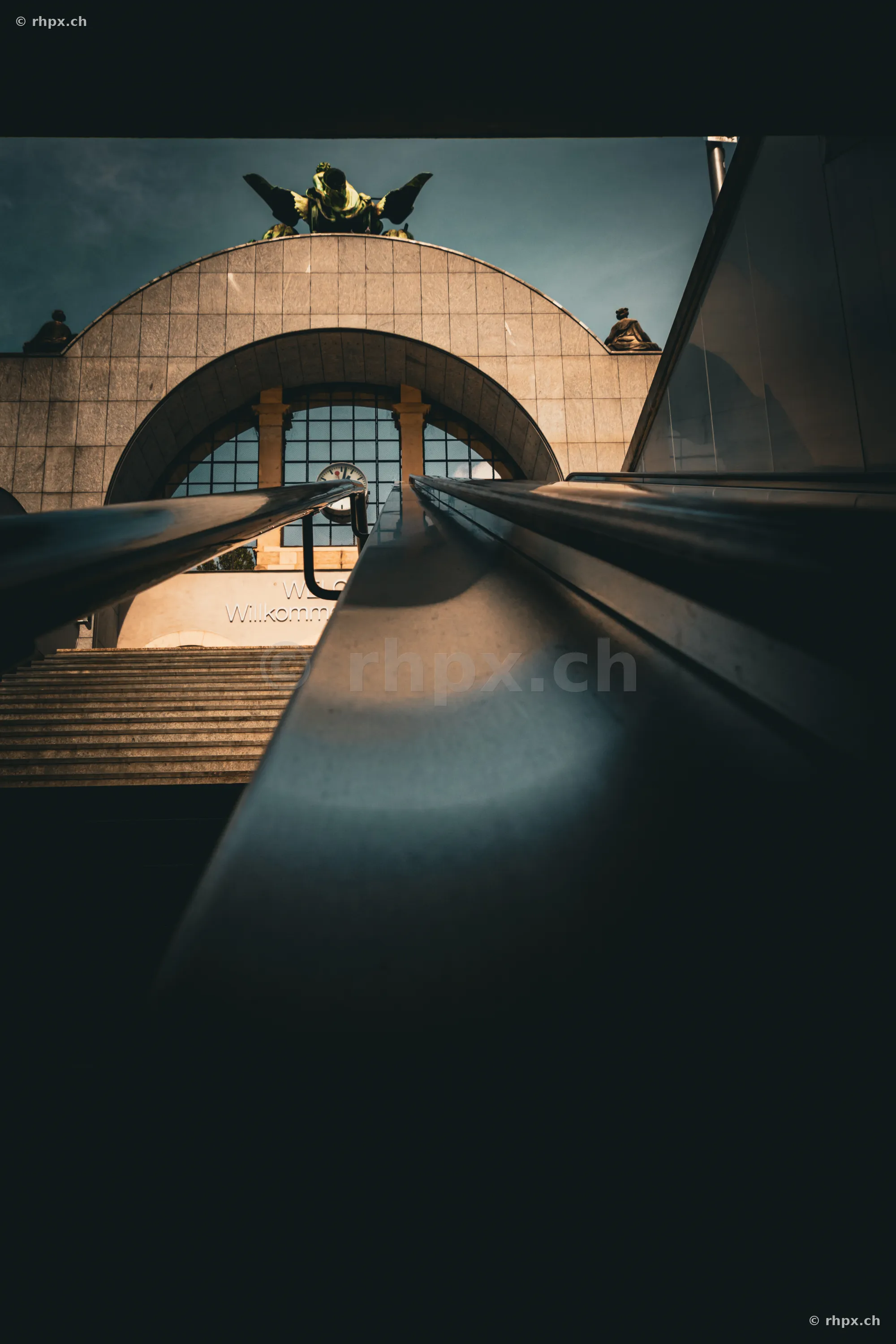 Blick von unten auf das Portal des Bahnhofs Luzern mit der Engelsskulptur von Richard Kissling
