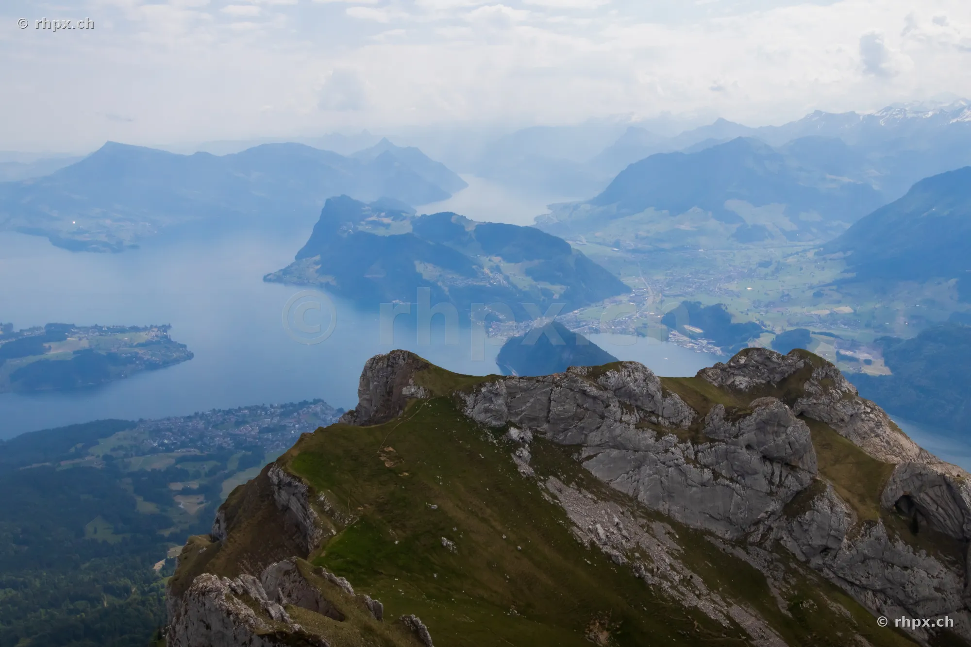 View from a rocky summit of Mount Pilatus looking down onto Lake Lucerne and the surrounding Central Swiss Alpine landscape