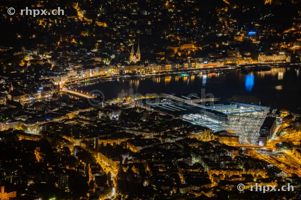 Nächtliche Luftaufnahme der Stadt Luzern mit See, Bahnhof und Hofkirche, fotografiert vom Pilatus aus.