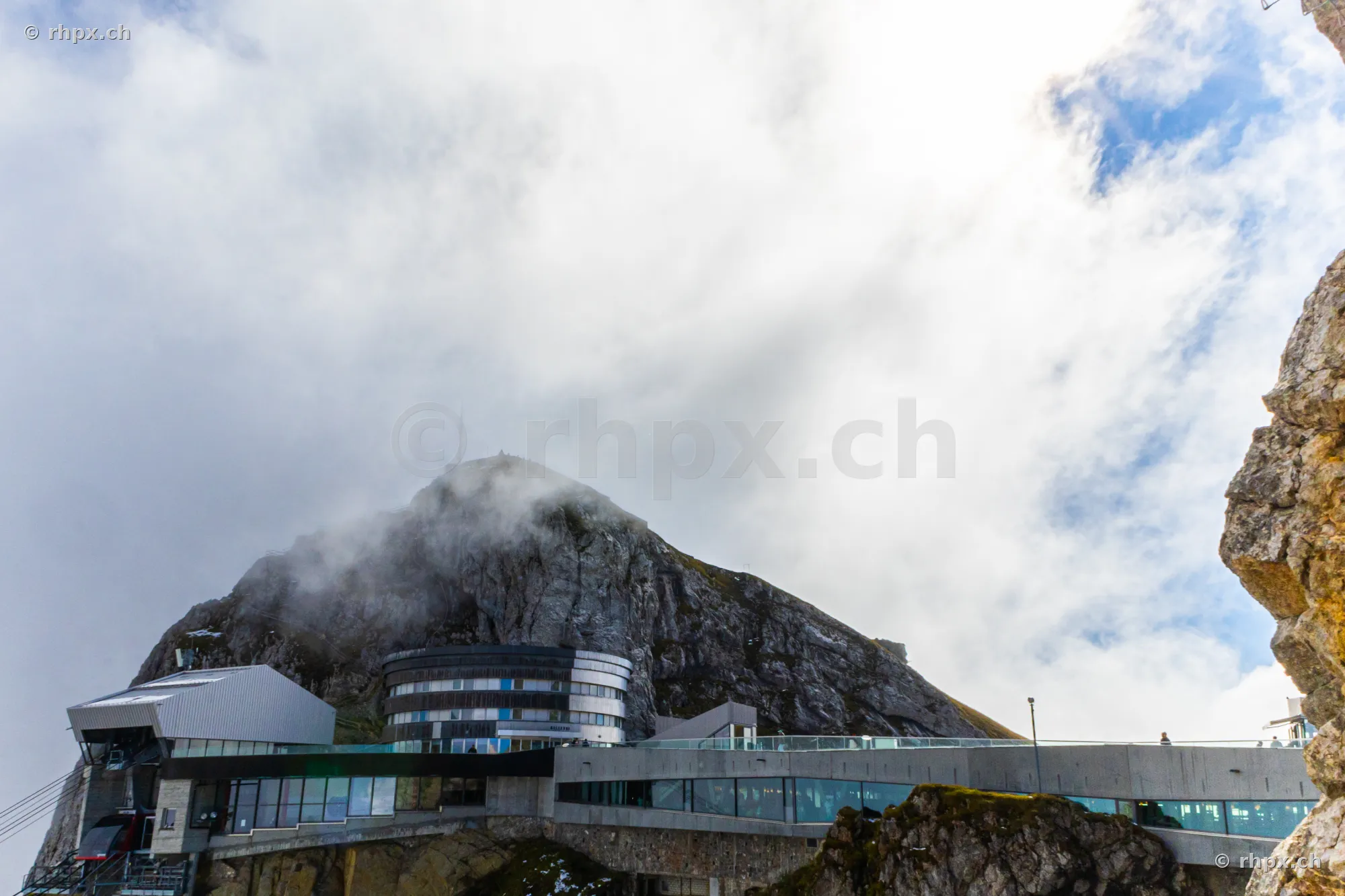 Blick auf die moderne Bergstation Pilatus Kulm am wolkenverhangenen Felsmassiv