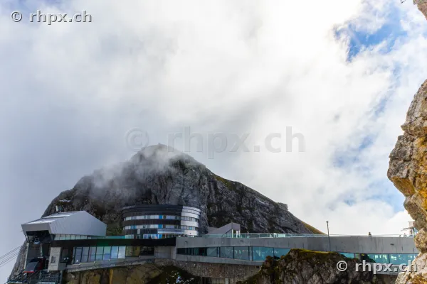 Blick auf die moderne Bergstation Pilatus Kulm am wolkenverhangenen Felsmassiv