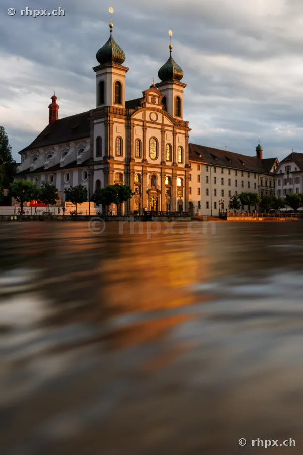 Jesuitenkirche Luzern mit Fluss Reuss im Vordergrund bei Sonnenuntergang
