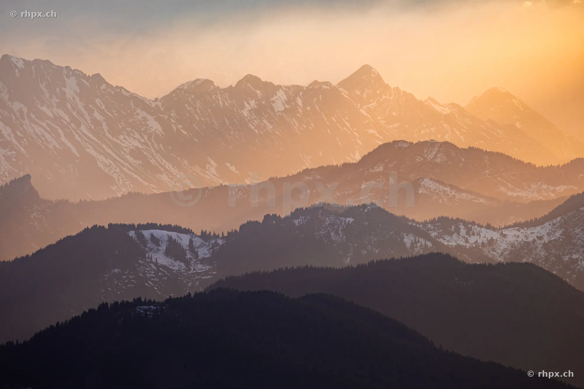 Layered mountain ranges near Lucerne in soft sunset light