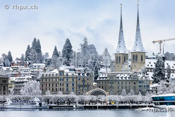 View across Lake Lucerne towards the snow-covered Hofkirche and Lucerne city in winter