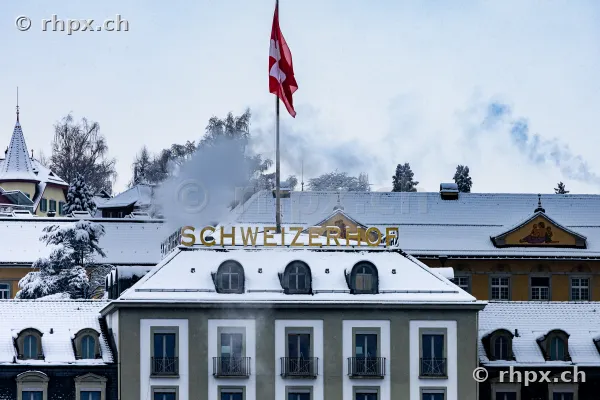 Hotel Schweizerhof Luzern mit verschneitem Dach und wehender Schweizer Flagge
