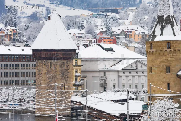 Snow-covered Wasserturm and historic buildings in Lucerne on a winter day