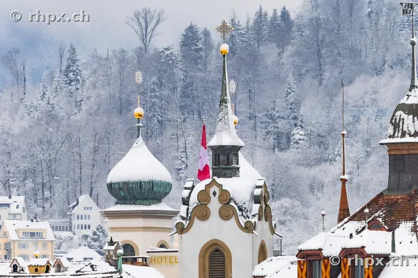 Close-up of snow-covered church towers and roofs in Lucerne during winter