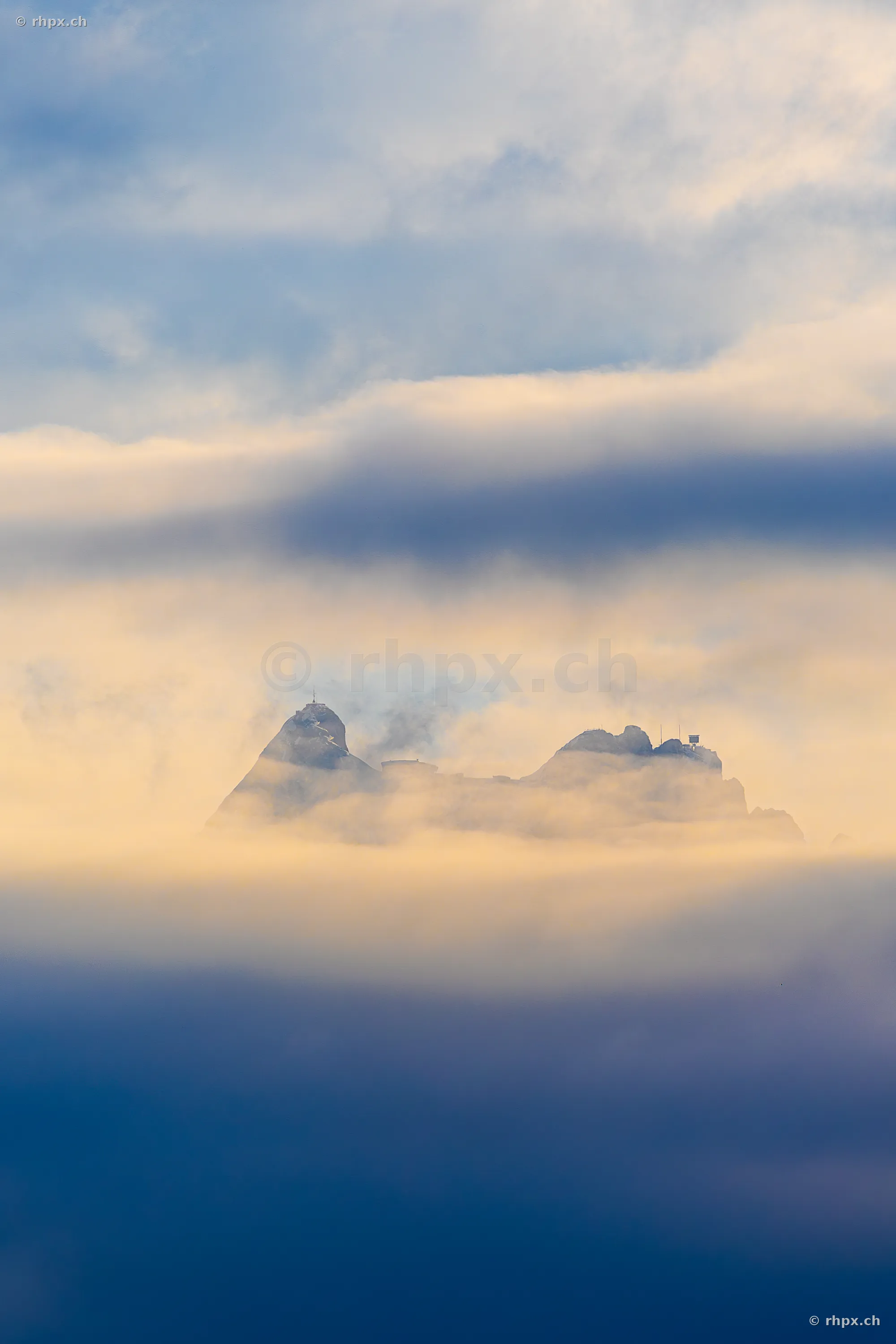 Der Gipfelbereich des Pilatus umgeben von Wolken und Nebel bei weichem Licht