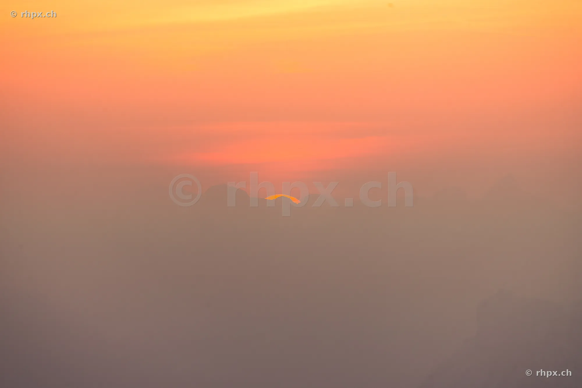Sun disc just before disappearing behind the Pilatus massif in Central Switzerland.