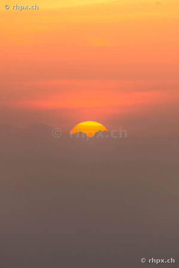 The setting sun dips behind the silhouettes of Mount Pilatus in Central Switzerland