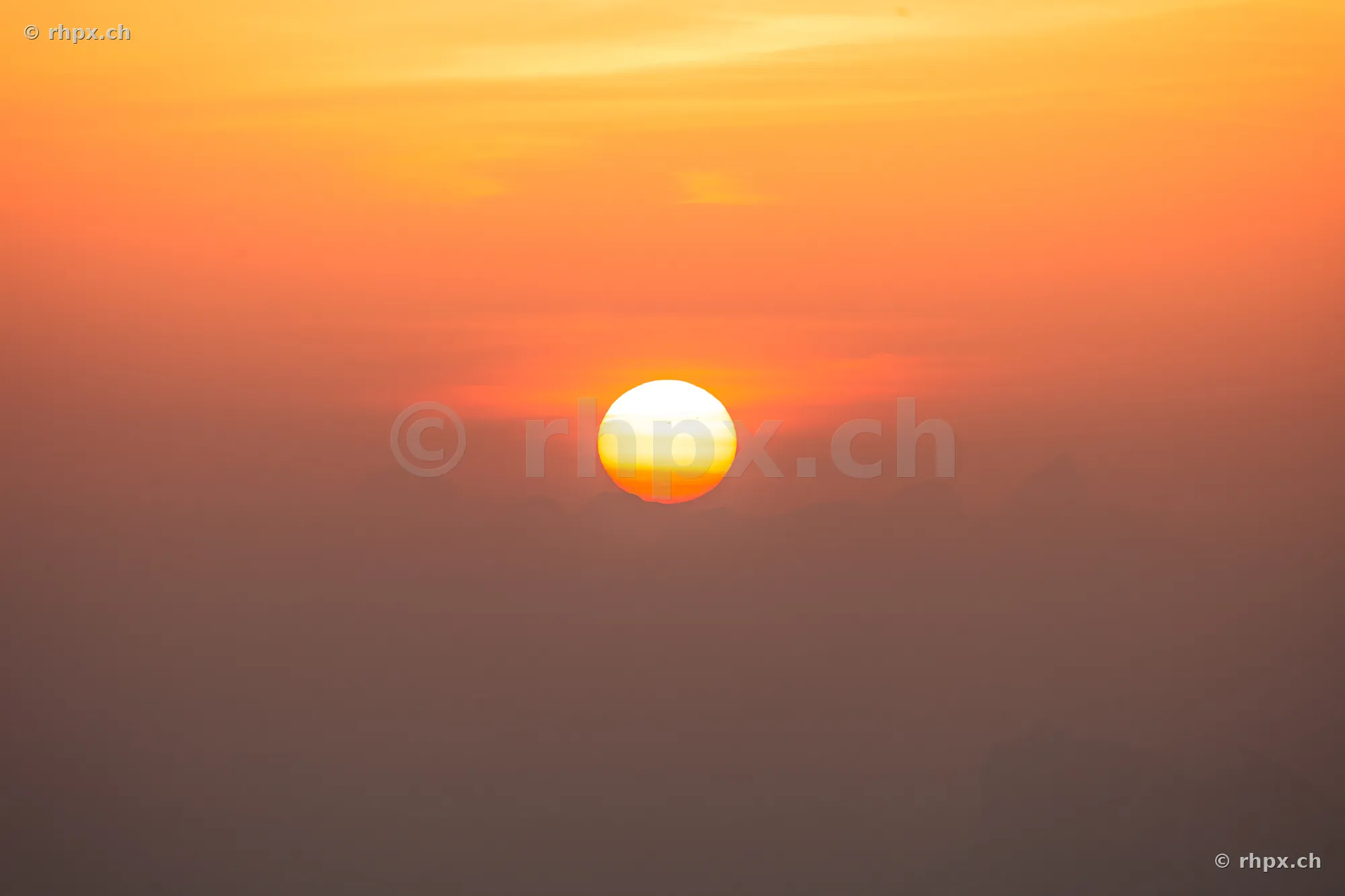 The sun is sinking below the horizon over Mount Pilatus.