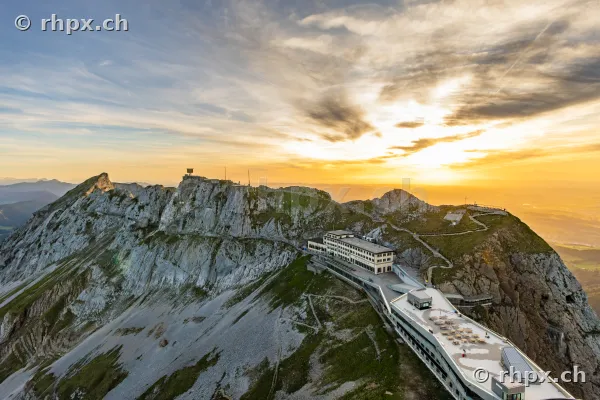 Luftaufnahme des Pilatus-Gipfels mit Hotelgebäude bei Sonnenuntergang