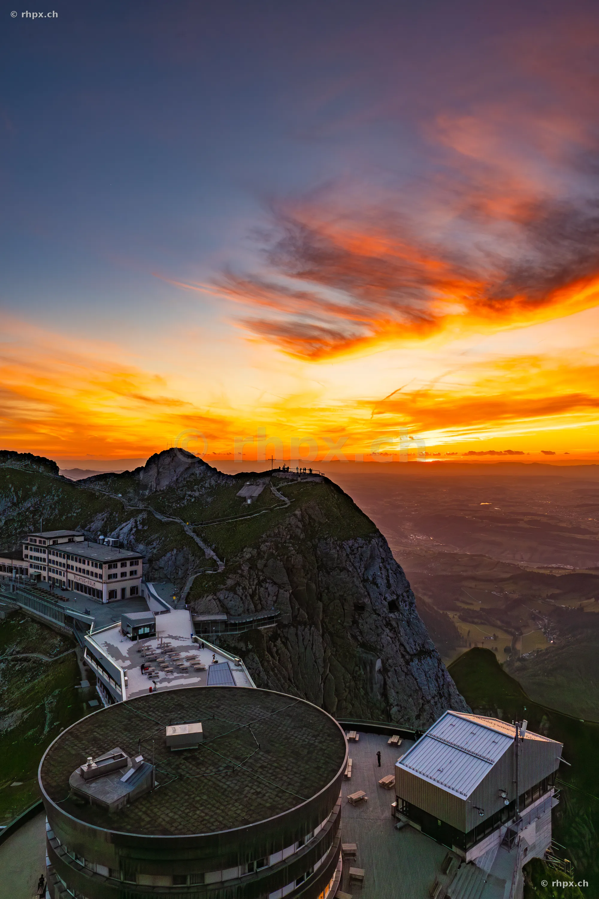 Aerial view of the hotel buildings at Pilatus Kulm during an orange sunset.