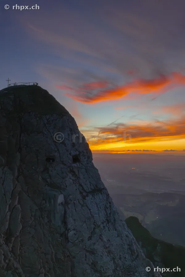 Blick auf den Gipfel des Pilatus bei Luzern während eines Sonnenuntergangs mit orangeroten Wolken.