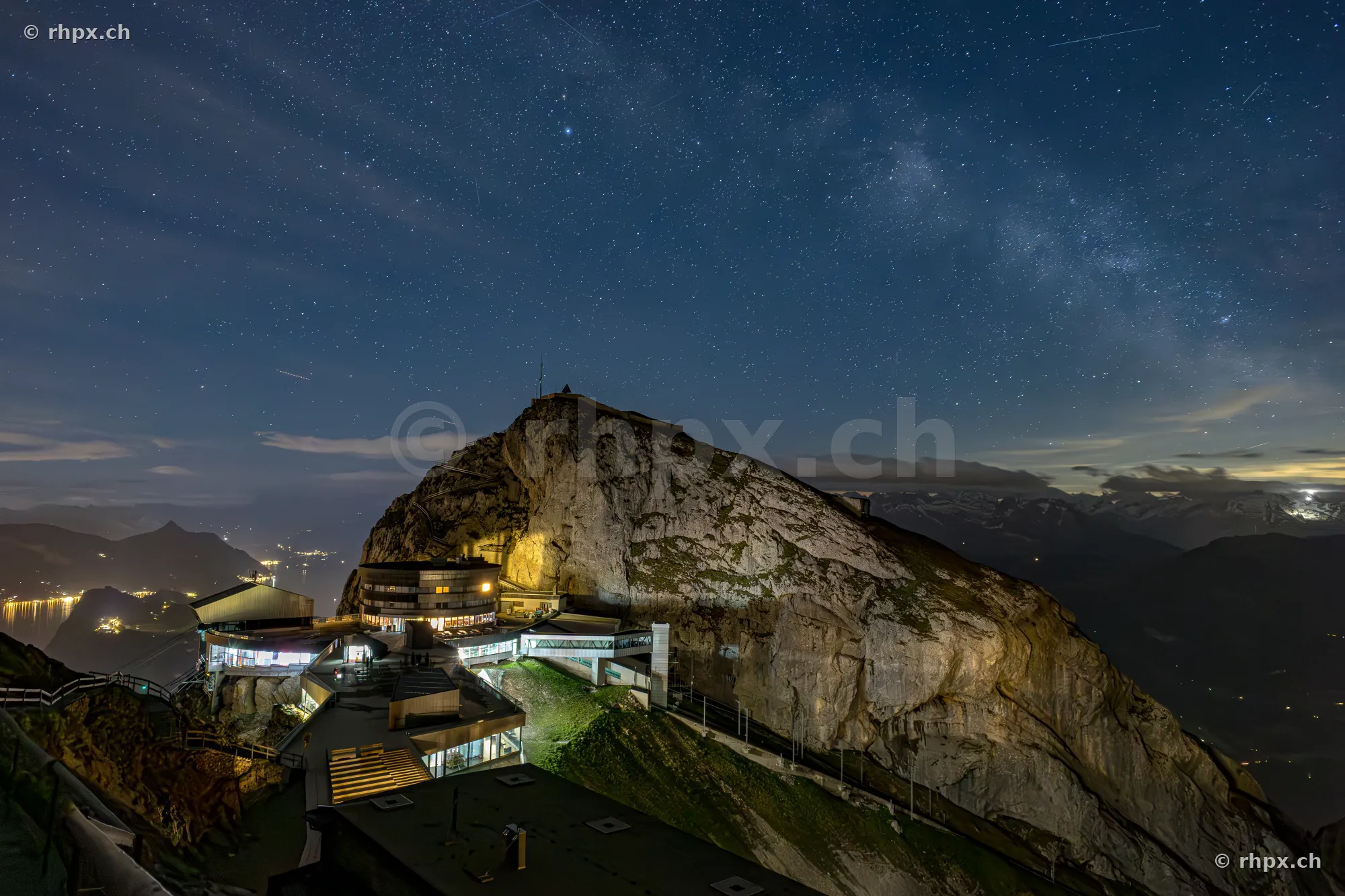 Night view of the Pilatus Kulm mountain station under a starry sky with the Milky Way