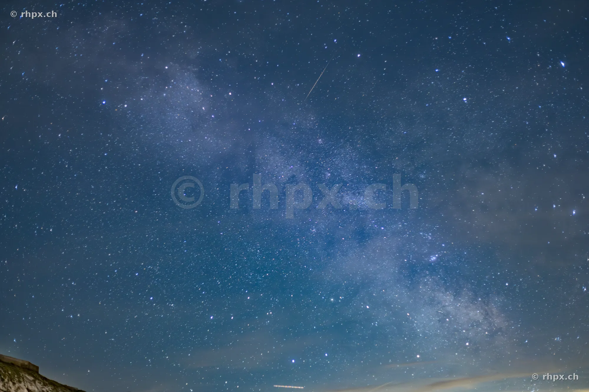 Night photography showing a starry sky above the silhouette of Mount Pilatus