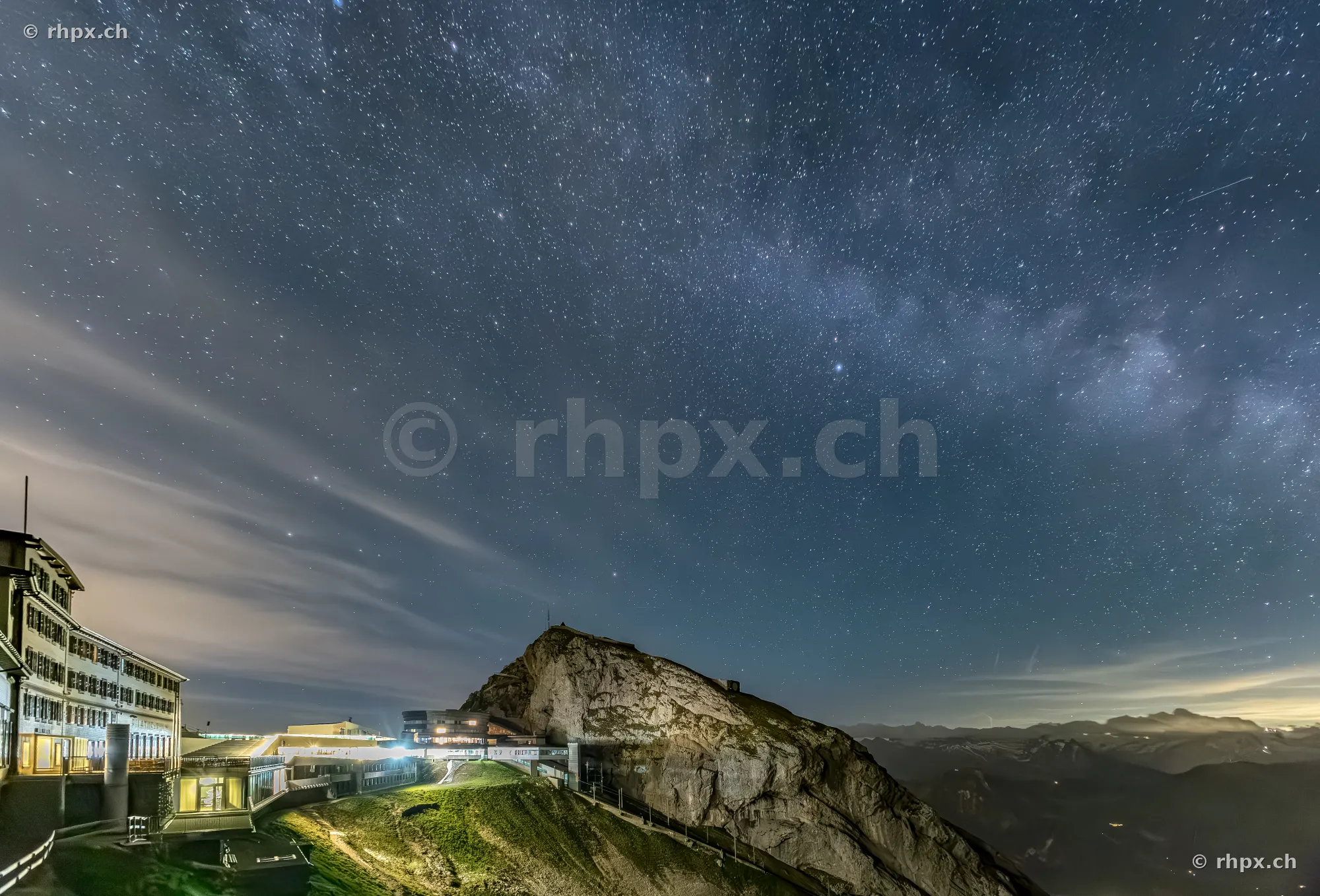 Night view of the Pilatus summit and hotel building under a starry sky.