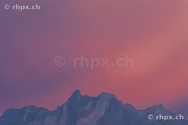 Silhouette of the Pilatus mountain massif against a pink evening sky