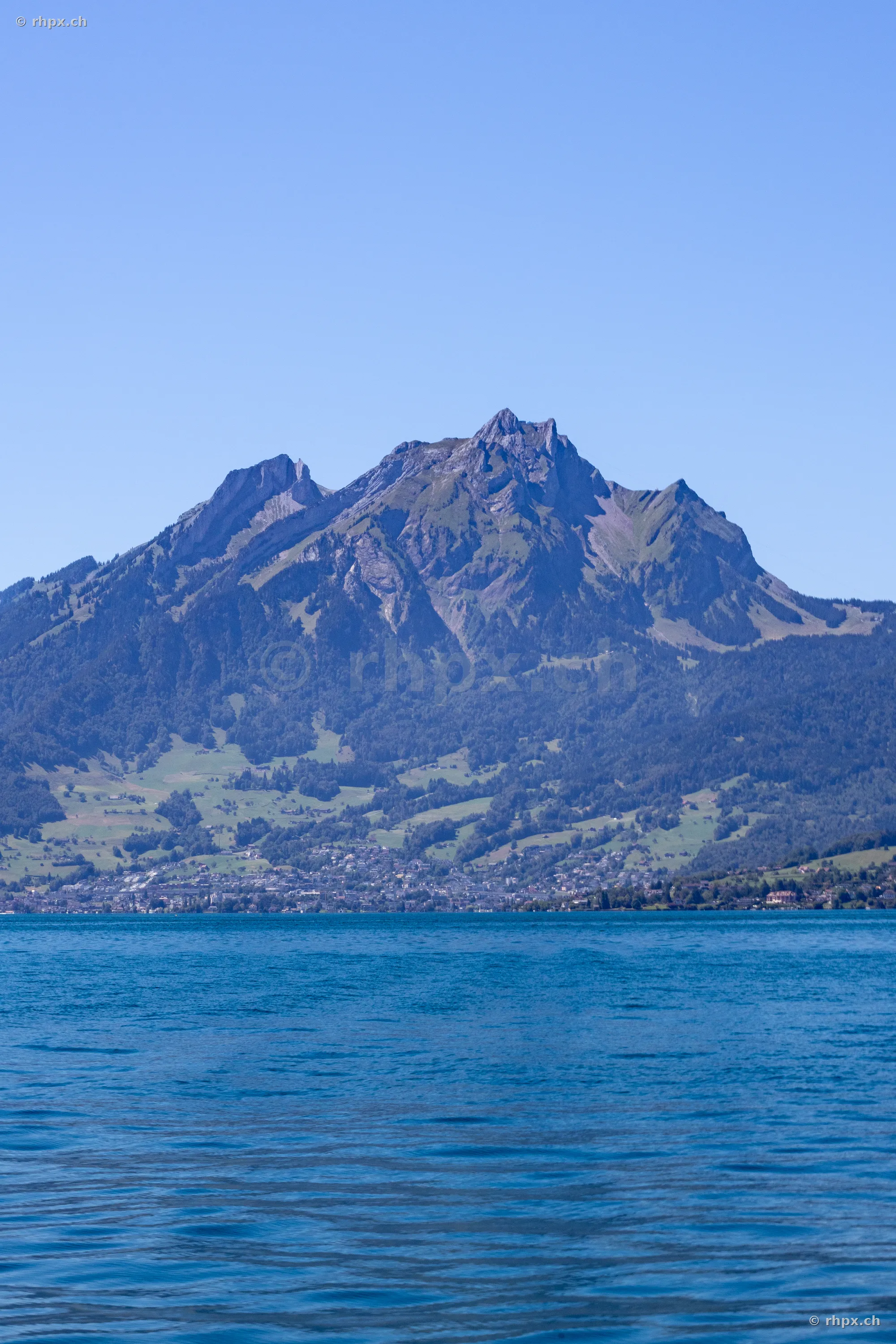 View of Mount Pilatus with Lake Lucerne in the foreground under a clear sky.
