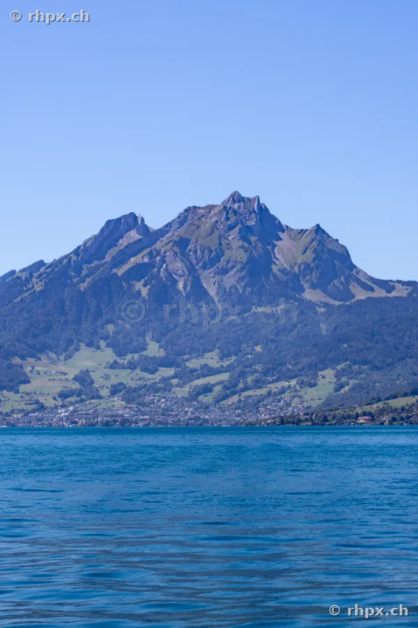 View of Mount Pilatus with Lake Lucerne in the foreground under a clear sky.