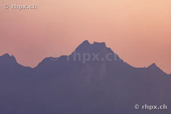 Dark silhouette of Mount Pilatus against a softly coloured evening sky