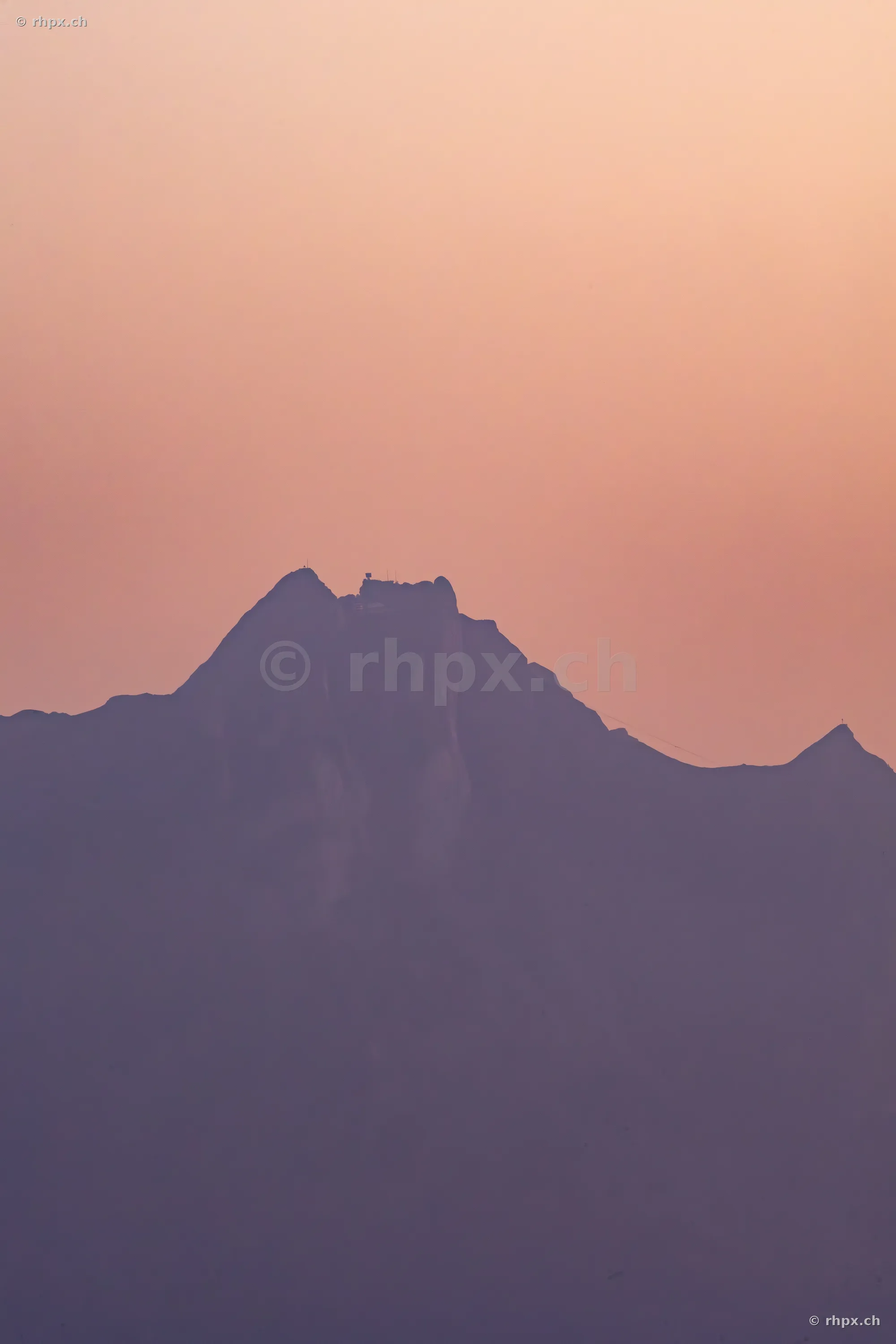 Dunkle Silhouette des Berges Pilatus vor einem sanft gefärbten Abendhimmel