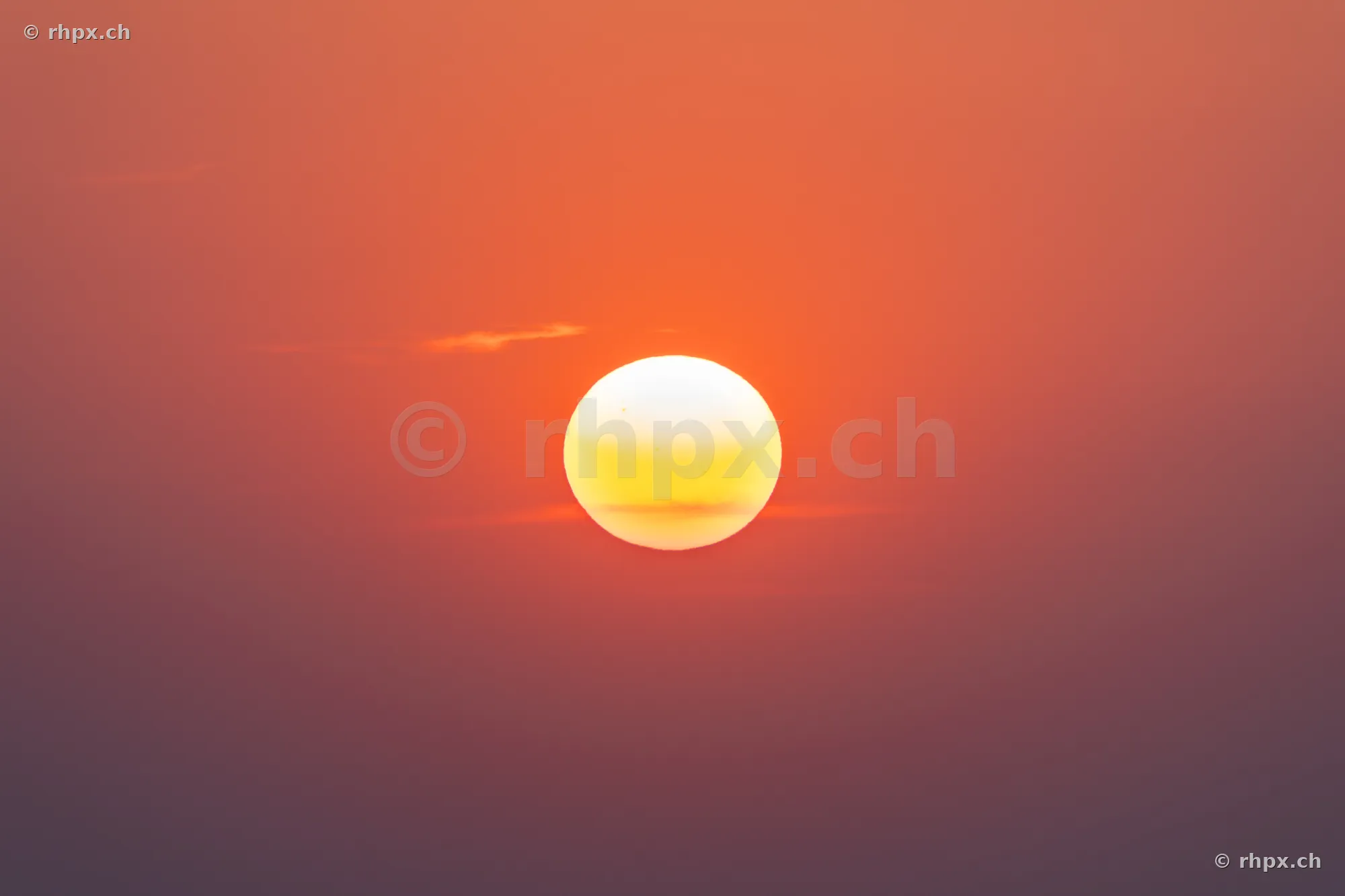 Die tiefstehende Sonne in einem rötlich gefärbten Himmel über Luzern.