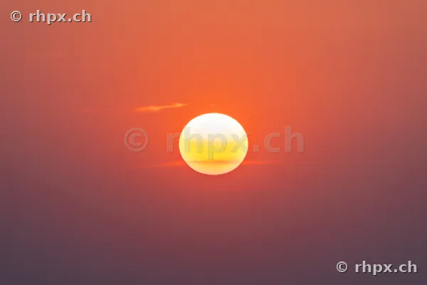 The low sun in a reddish coloured sky over Lucerne.