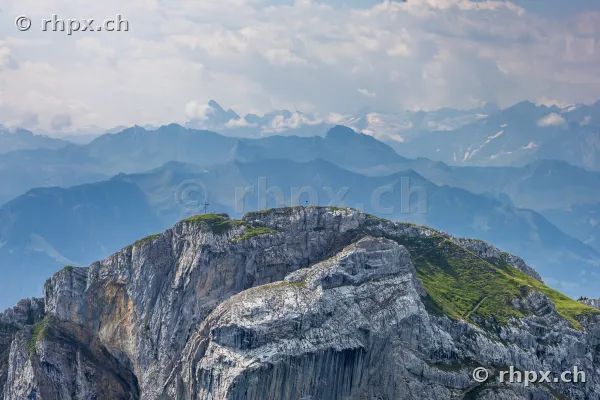 View of the prominent Pilatus rock massif with its summit and the Alps in the background.