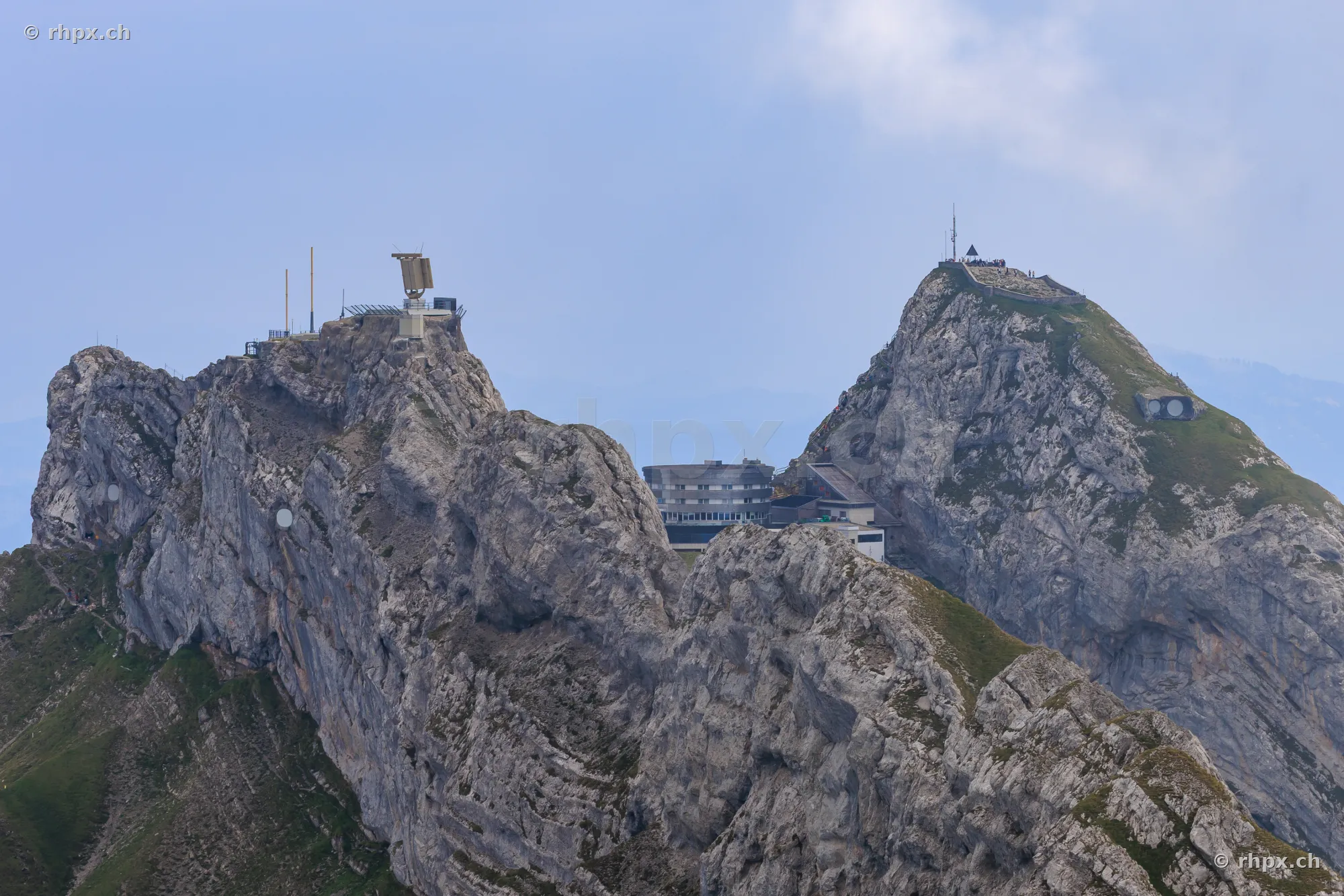View of the Pilatus peaks with hotel and transmission towers in daylight