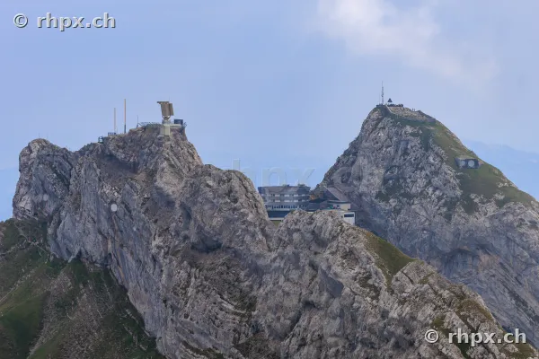 View of the Pilatus peaks with hotel and transmission towers in daylight