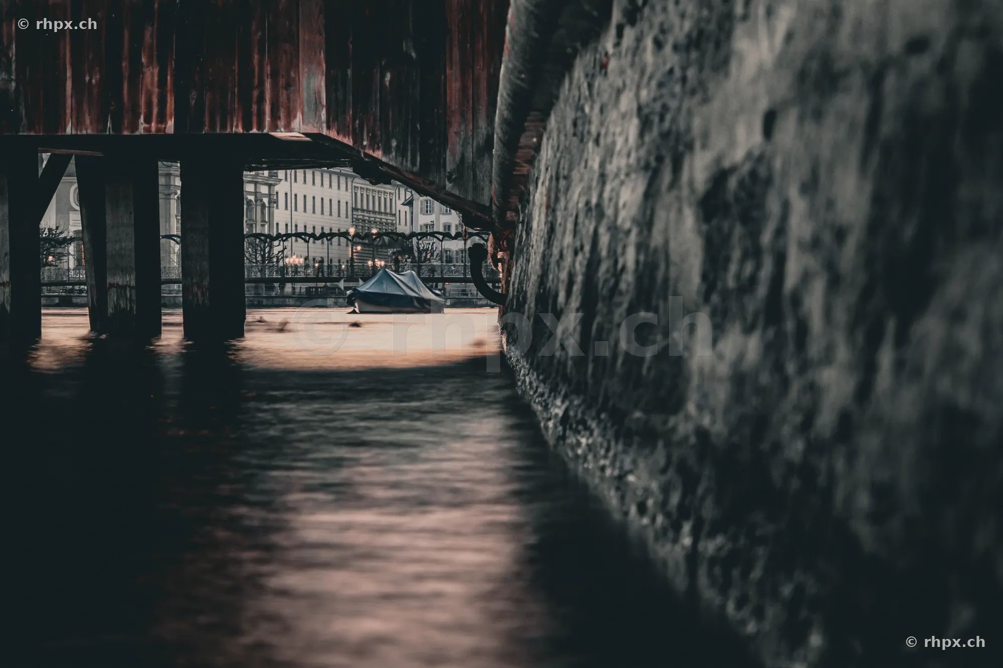 Ein kleines Boot unter der hölzernen Spreuerbrücke in der Reuss in Luzern.