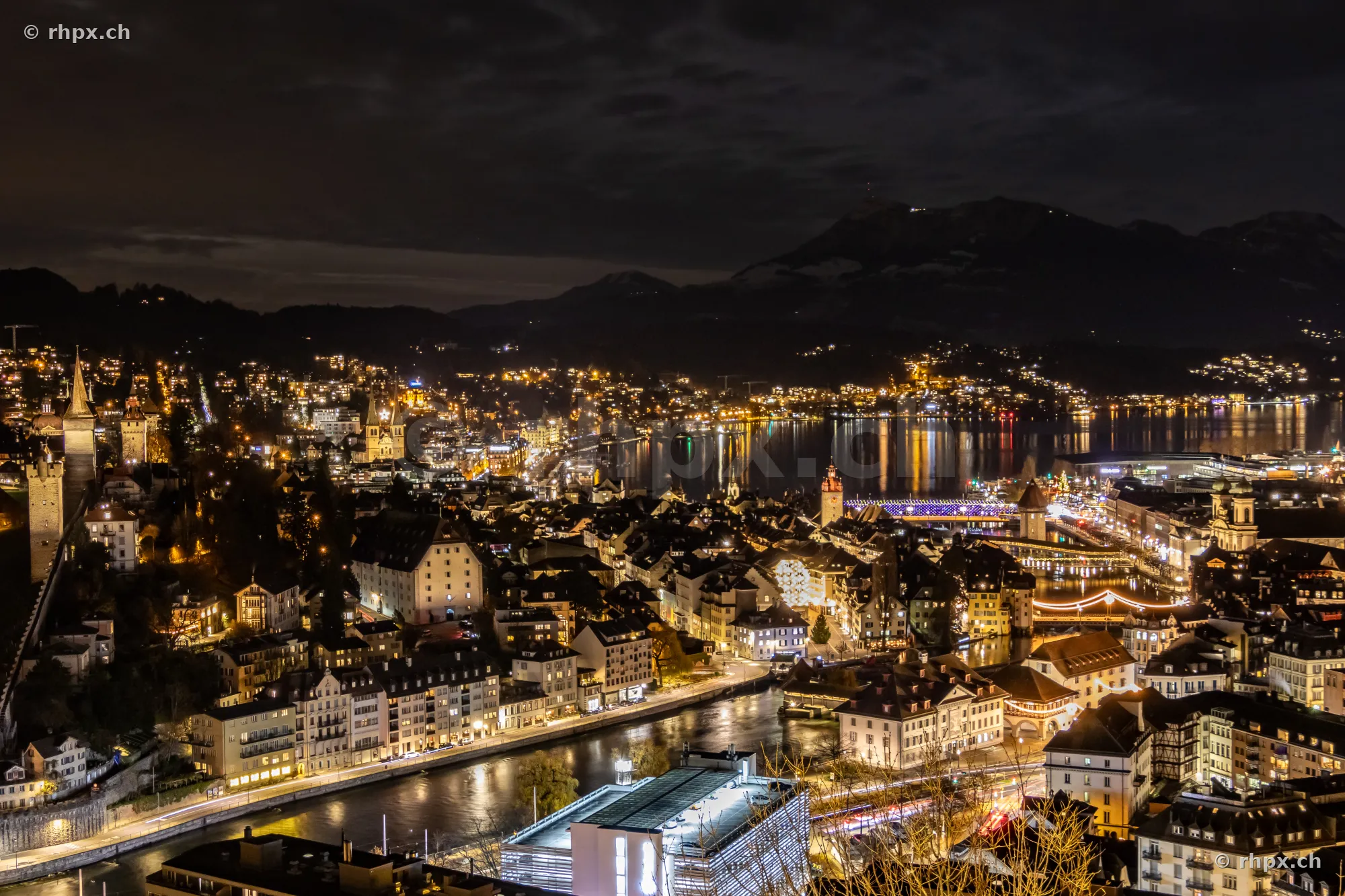 Nachtaufnahme von Luzern mit weihnachtlicher Beleuchtung und Blick auf Reuss und Vierwaldstättersee