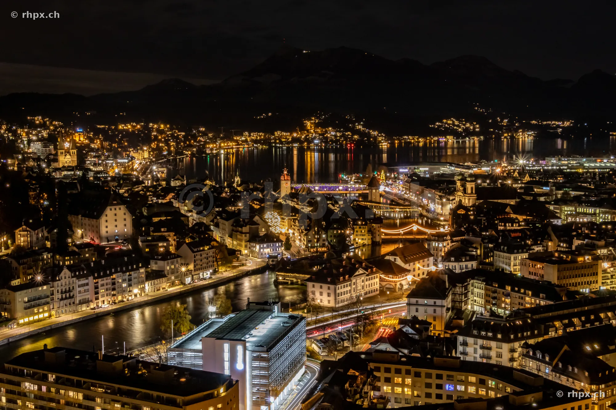 Nächtlicher Blick auf die weihnachtlich beleuchtete Altstadt von Luzern mit Reuss und Vierwaldstättersee