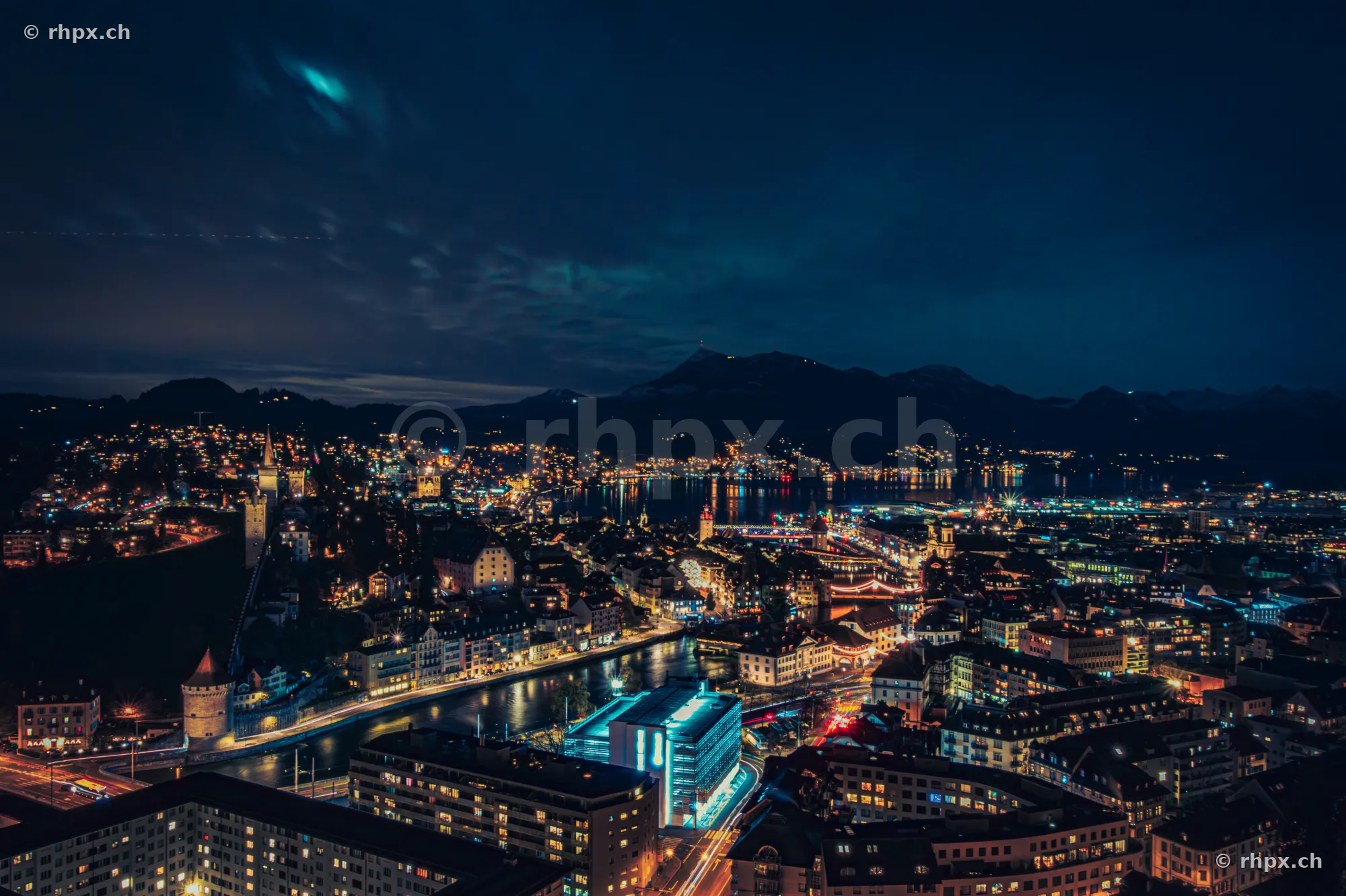 Night view of the Christmas illuminated city of Lucerne with Lake Lucerne and mountains in the background