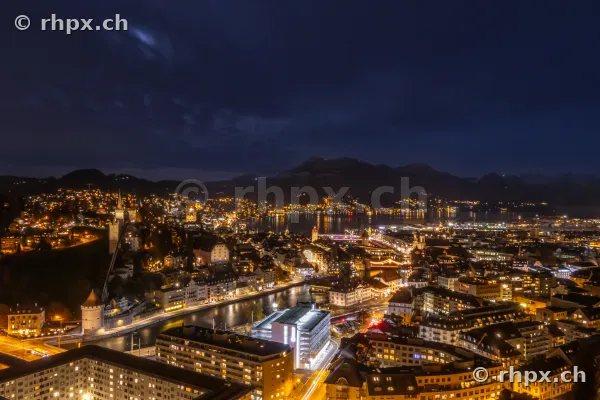 Night view from above of the illuminated city of Lucerne during Christmas time with the Reuss river