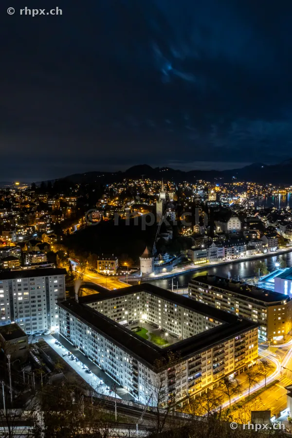 Luftaufnahme der nächtlichen Stadt Luzern mit beleuchteten Häuserzeilen