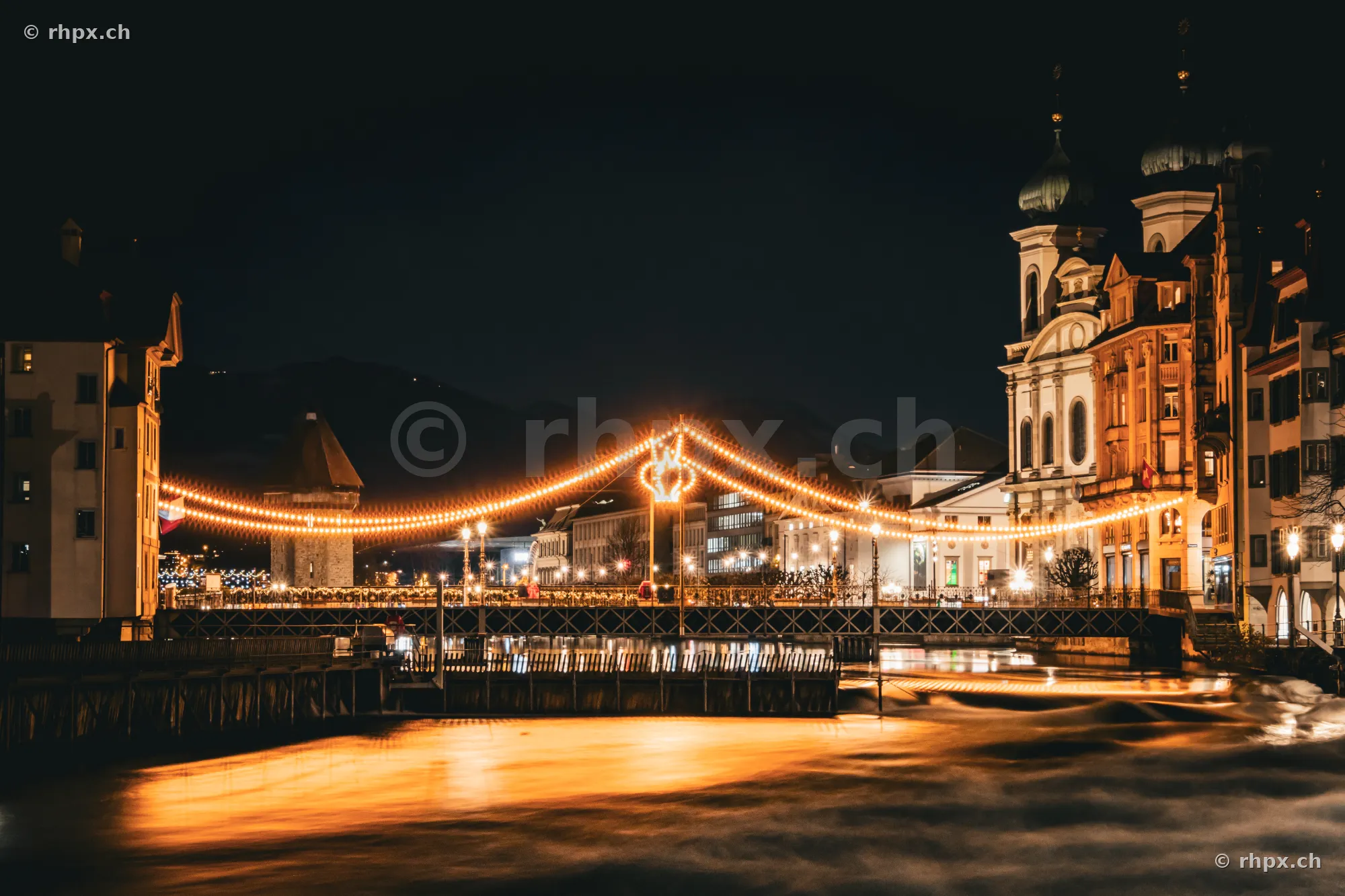Christmas lights above the Reuss river in Lucerne at night