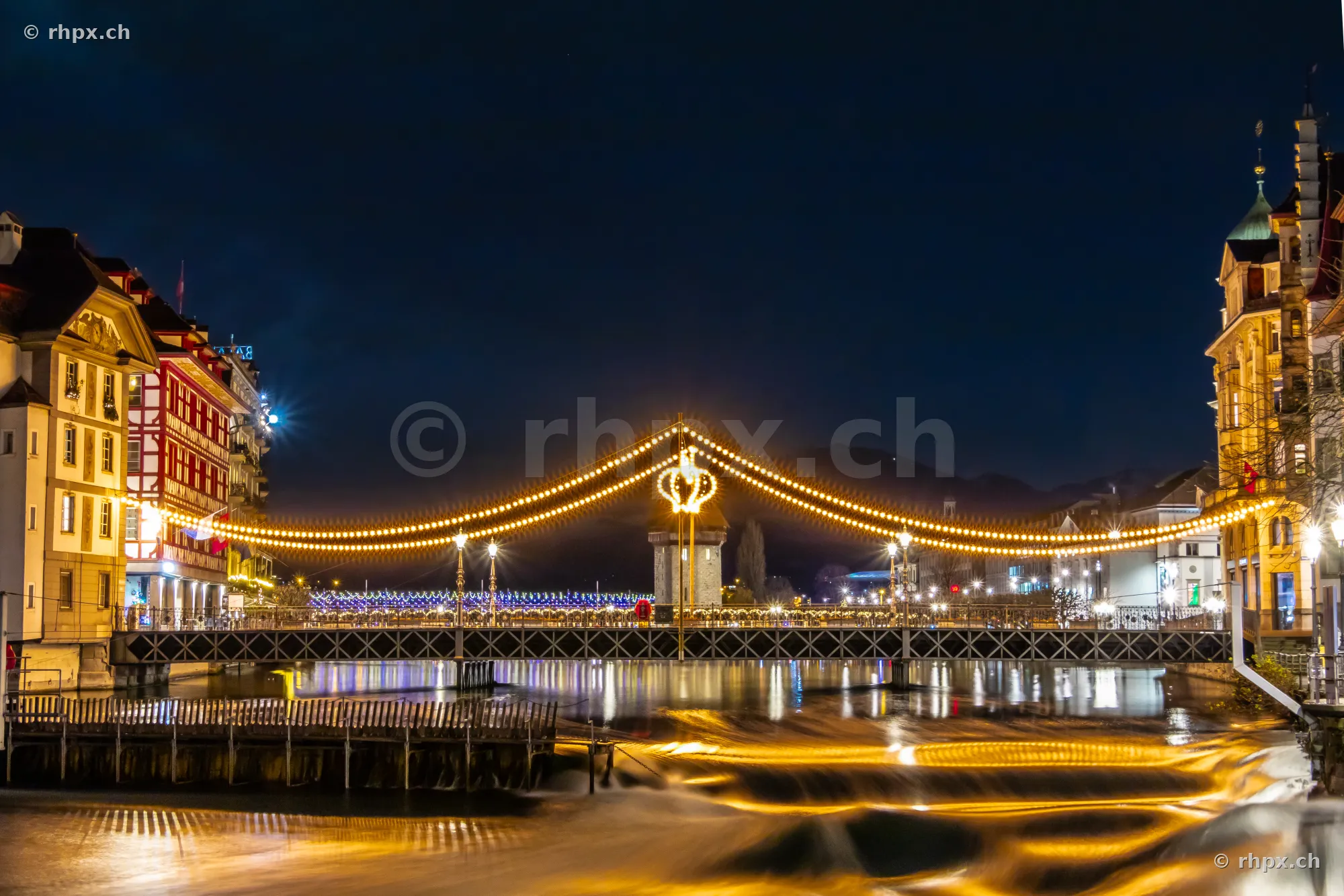 Christmas string lights over the Reuss river in Lucerne at night