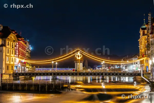 Christmas string lights over the Reuss river in Lucerne at night