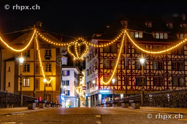 Weihnachtliche Lichterketten in einer nächtlichen Gasse der Luzerner Altstadt