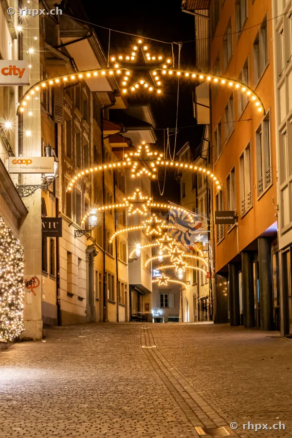 Nächtliche Gasse in Luzern mit leuchtenden Sternen-Lichterketten