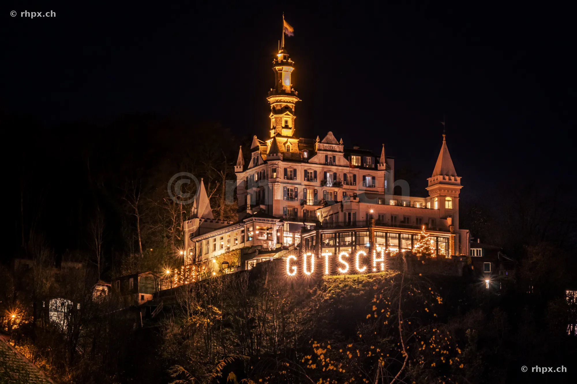 The illuminated Château Gütsch on the hillside above the city of Lucerne at night.